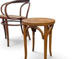 two wooden chairs and a small table on a white surface