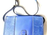 a blue purse with a gold ring on it