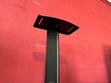 a red wall with a black speaker on top of it
