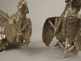 two metal birds that are standing next to each other