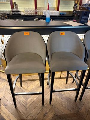 three grey bar stools sitting on top of a wooden floor