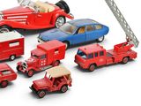 a lot of toy cars and a firetruck on a white surface