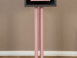 a pink and black cabinet on a pedestal in a room