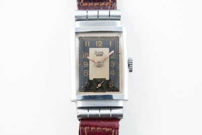 une montre posée sur une surface blanche