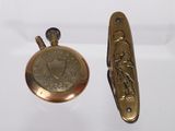 two antique brass pocket watches and a brass pocket watch on a white surface