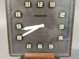 a clock that is sitting on a stand on a table