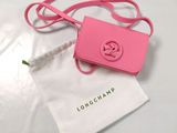 a small pink bag with a pink handle on a white table