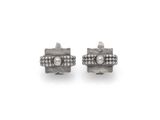 une paire de boucles d'oreilles en diamant et en argent sur fond blanc