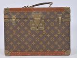 an old louis vuitton suitcase sitting on top of a white surface