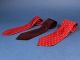 three red and black ties on a blue background