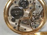 a close up of a pocket watch on a white surface
