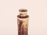 a brown and white vase sitting on a white surface