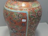 a large orange vase with a lid sitting on a table