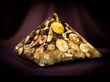 a picture of a pyramid made of rocks with a clock on it
