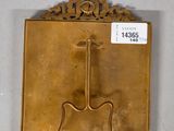 a gold plaque with a guitar on it on the wall