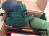 a box with a sander and a bottle in it