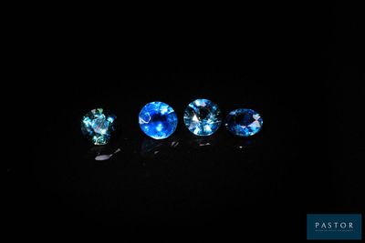 un ensemble de trois saphirs bleus posés sur une surface noire