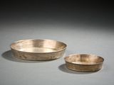 paire de bols en argent avec des anses et des bords sur une surface grise