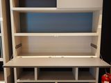 a white desk with shelves and a red fire extinguisher