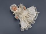 a baby doll that is laying down on a blue surface