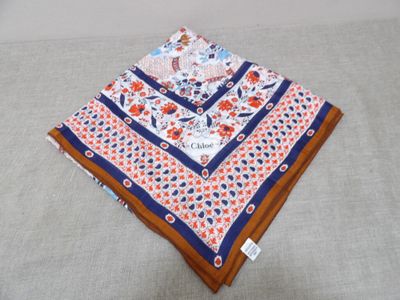 un mouchoir orange et bleu posé sur une table blanche