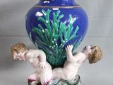 un vase bleu orné d'une figurine représentant un garçon et une fille