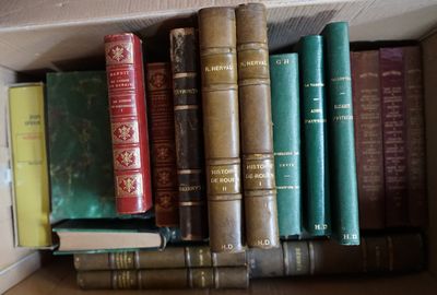 de nombreux livres qui se trouvent sur une étagère, dans une boîte