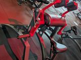 rows of exercise equipment in a gym with red flooring