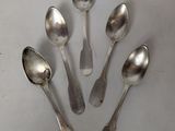 six silver spoons are arranged in a circle on a white surface