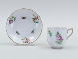 a white cup and saucer with a floral design on it