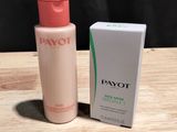 un gros plan sur un flacon de lotion posé à côté d'une boîte sur une table