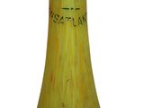 un vase jaune orné d'une inscription noire, posé sur une surface blanche