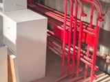une borne d'incendie rouge posée à côté d'une pile de tuyaux rouges