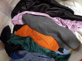 a pile of clothes sitting on top of a bed