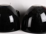 deux casques noirs posés l'un à côté de l'autre sur une surface blanche