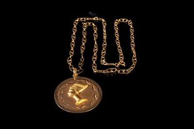 collier plaqué or avec un visage de femme suspendu à une chaîne