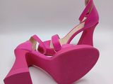 a close up of a pair of pink shoes on a white surface