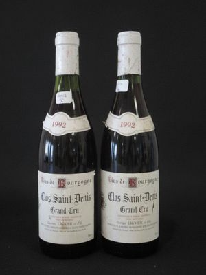 two bottles of wine sitting on top of a table next to each other
