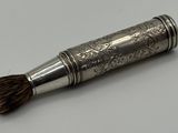 une petite brosse en argent posée sur une table