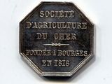 une pièce d'argent sur laquelle figure l'image d'un homme