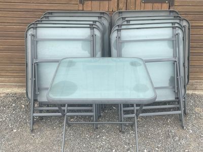 four chairs and a table with a glass top