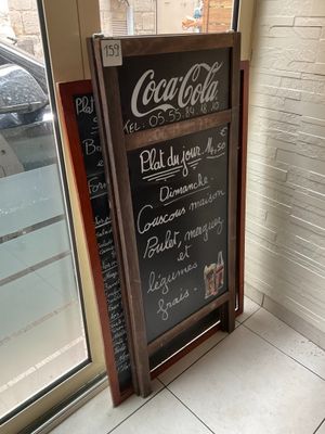 a chalk board with a menu written on it in front of a window