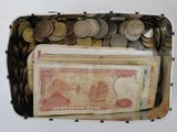 une boîte remplie d'argent et de pièces posée sur la table