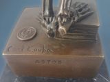 a bronze statue of a person standing on top of a book