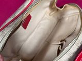 a person holding a purse that is open on a pink surface