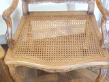 a wooden chair that has a woven seat on it