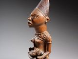 une statue en bois d'un homme avec un chapeau sur la tête