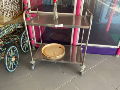un chariot métallique surmonté d'un saladier, devant un magasin