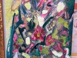un tableau posé par terre, à côté d'une photo représentant un vase de fleurs