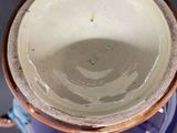 a close up of a blue and white vase with a brown rim